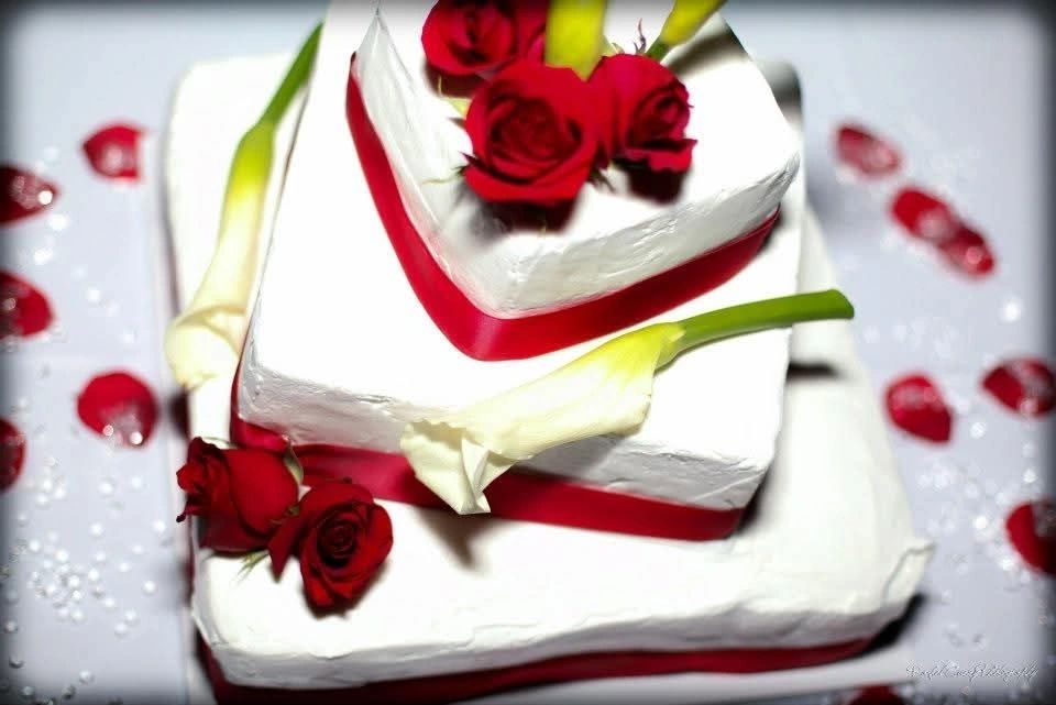 White wedding cake with red roses